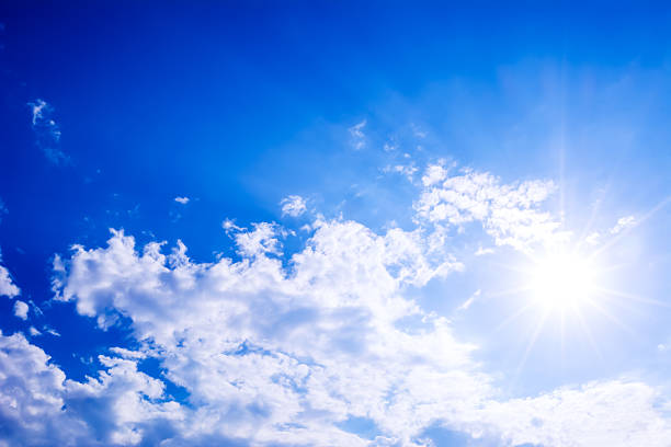 istock Idyllic clear blue sky with fluffy clouds and sunbeams 546013308