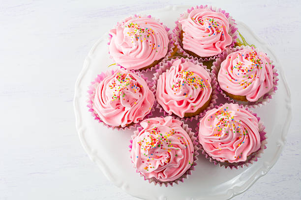 istock Pink cupcakes  on cake stand top view 546014092