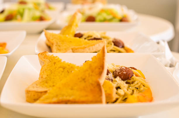Photograph image of several plates of spaghetti with sausage.