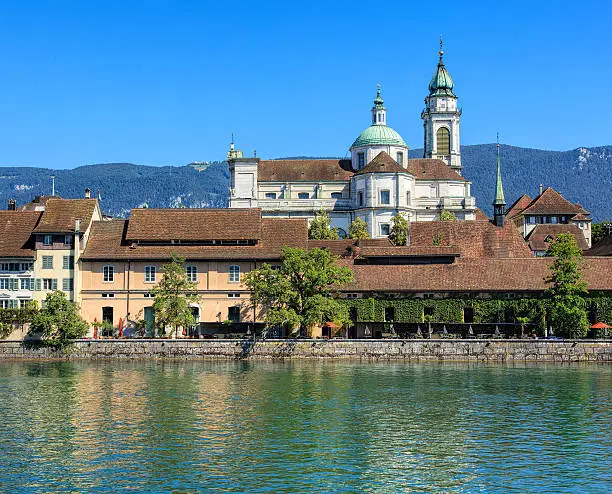 View on the city of Solothurn in Switzerland over the Aare river with the towers of the St. Ursus cathedral in the background.
