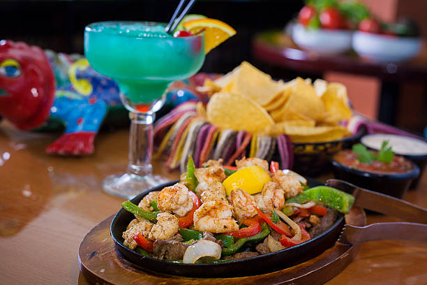 Steak and Shrimp fajitas Steak and shrimp fajitas with a blue margarita, such and chips fajita photos stock pictures, royalty-free photos & images