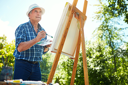 Cropped shot of a senior man painting in the park
