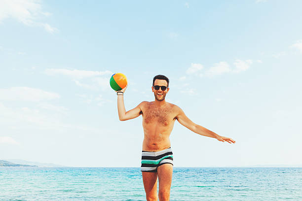 istock Young handsome man at the beach trowing the ball 546026040