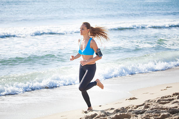 istock Young woman jogging on the beach 546026390
