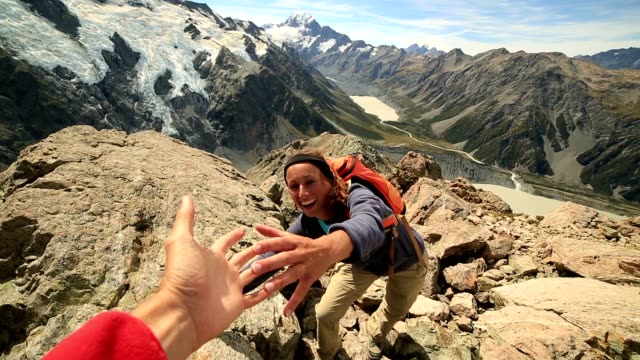 Hiker pulls out his hand to get assistance from teammate