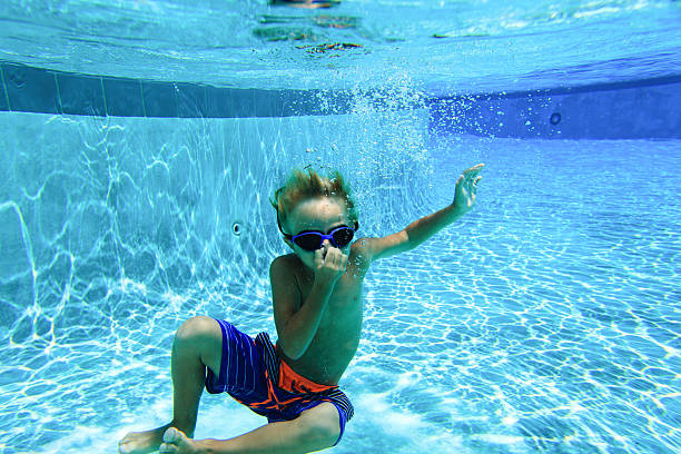 istock little boy learns swimming underwater 546164020