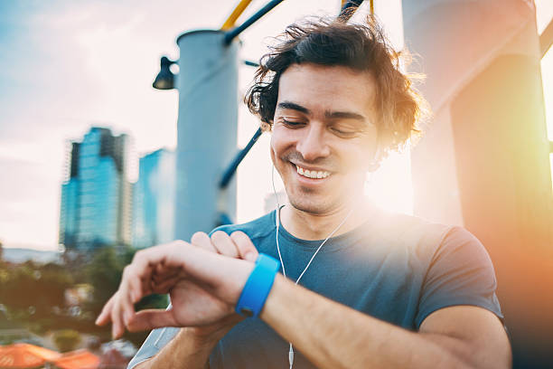 atleta comprobando su reloj inteligente - sun watch fotografías e imágenes de stock