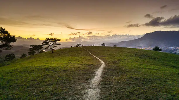 beautiful sunsets in a hilly area in Dalat, Vietnam. trails on hill  leading down to the valey bottom in sunset