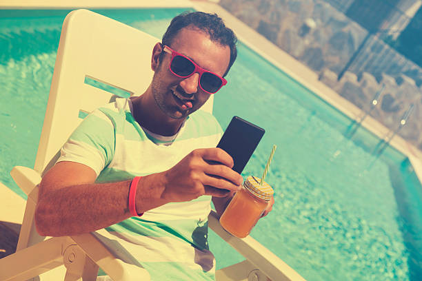 istock Young man on the pool with cellphone. 546164442
