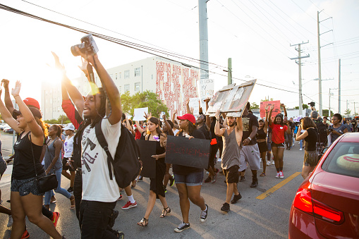 Miami, United States - July 9, 2016: Group of peaceful protestors holding black lives matter related content march on the streets of Miami in the design district.