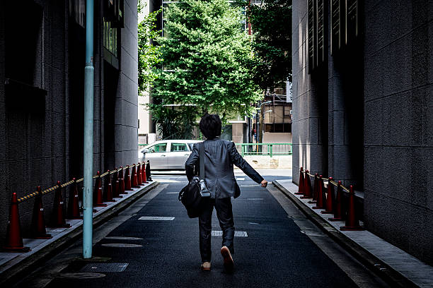 istock Asian businessman walking along business district 546166956