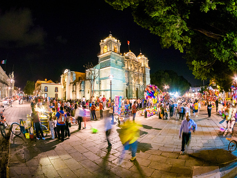 Oaxaca, Mexico - February 22, 2014: View of people walking around the lively facade of Cathedral of Our Lady of the Assumption (Catedral de Oaxaca) in Oaxaca, Mexico.