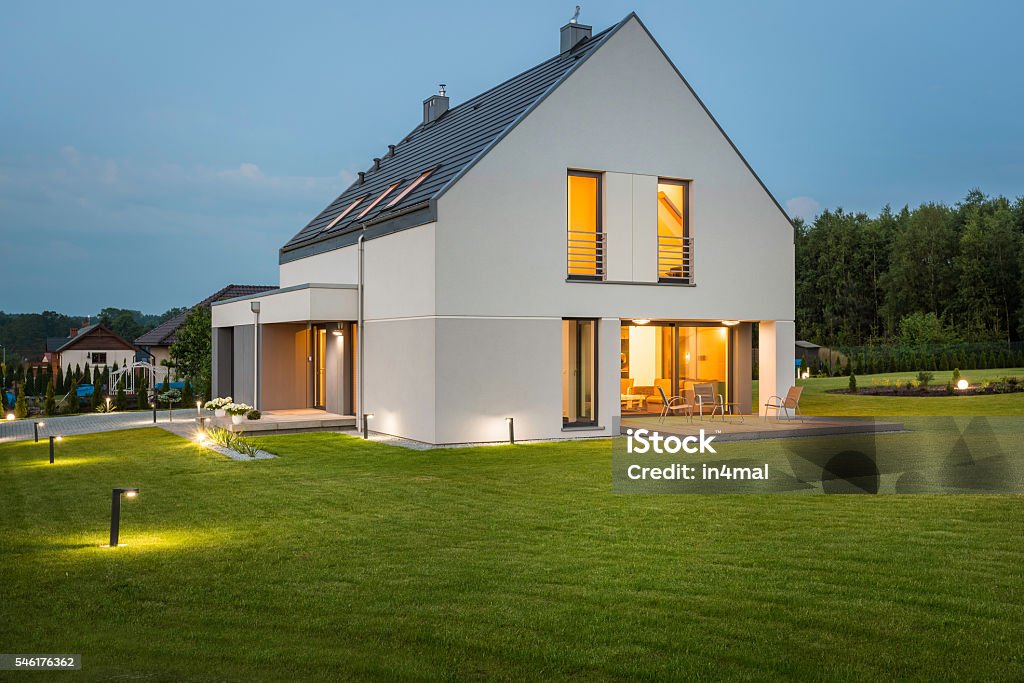 New house ideal for family Big light house in new design with wide lawn and outdoor lighting, night view Lighting Equipment Stock Photo