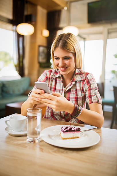 istock Smiling young businesswoman using mobile phone in modern cafe 546176886
