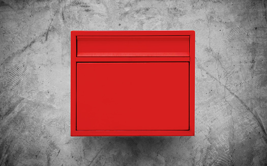 Red mailbox on concrete wall