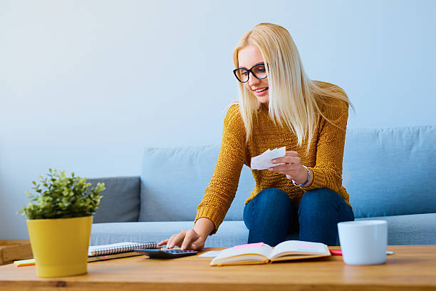 istock Young woman with bills calculating finances, sitting on sofa 546177628