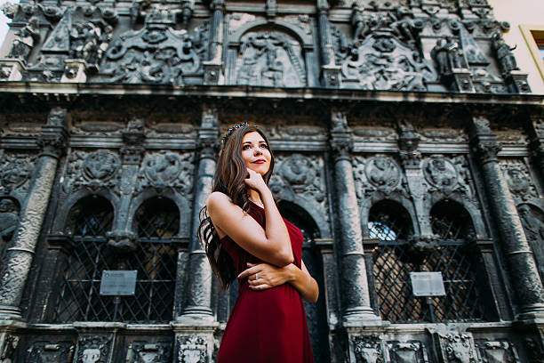 istock Cheerful young brunette in a red dress posing with old 546178084