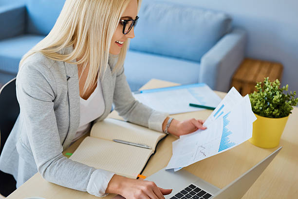 istock Happy young woman working with financial data from home office. 546178272