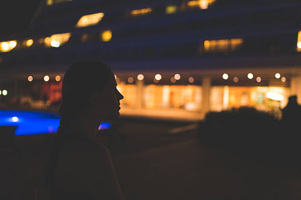 Woman standing in the dark surrounded with hotel lights