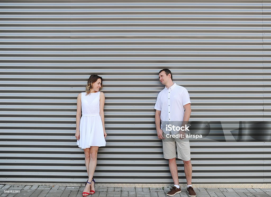 Beautiful couple costs at a motley wall. Beautiful couple costs at a motley wall. They look each other in the face. Adult Stock Photo