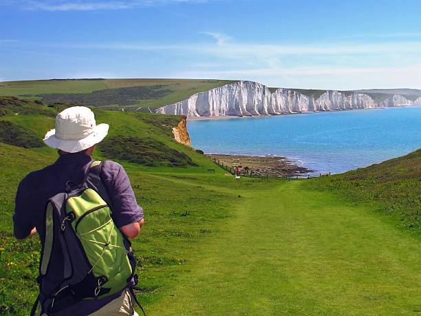 hiker and white cliffs of Seven Sisters, East Sussex, England stock photo
