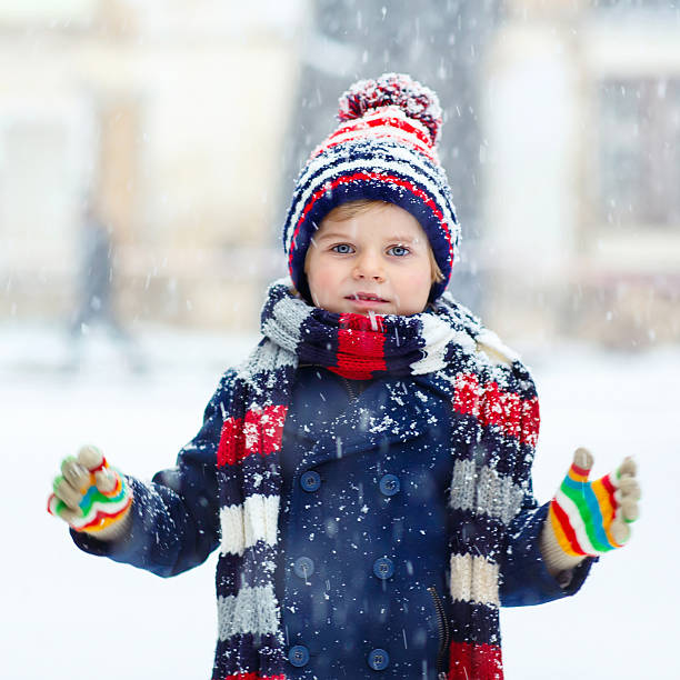 istock Happy kid boy having fun with snow in winter 546185944