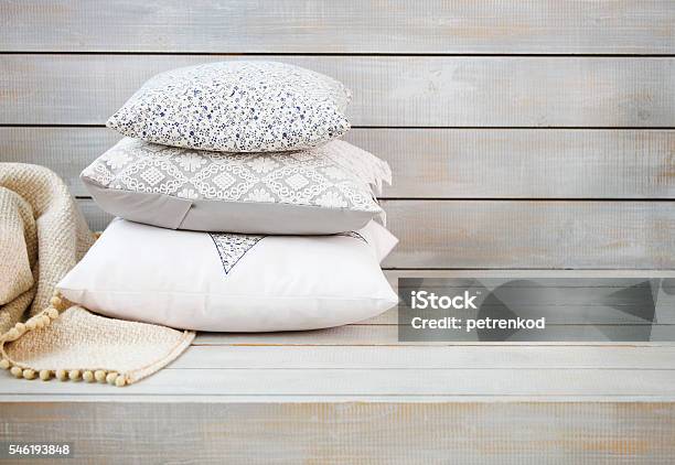 Cozy Pillows And Plaid On The Light Wooden Background Stock Photo - Download Image Now