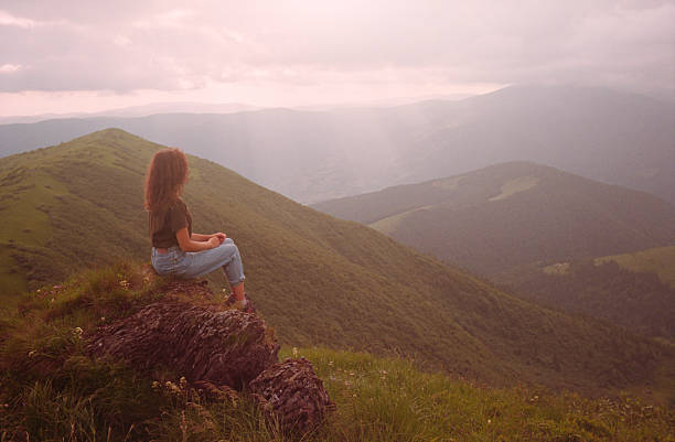 istock Woman sitting on a rock in the mountains 546196302