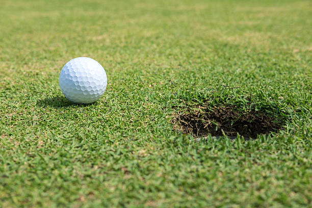 istock White golf ball on green near hole 546196616