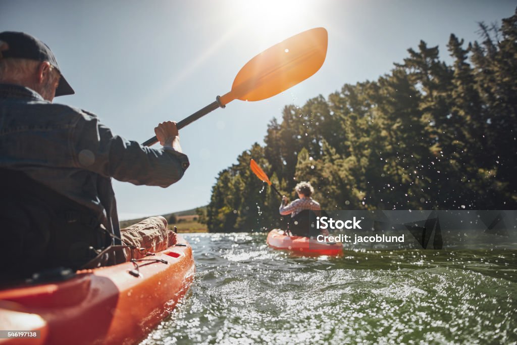 Senior Pareja de paseo en kayak en un lago - Foto de stock de Lago libre de derechos