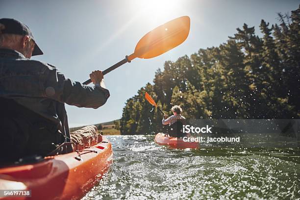 Senior Pareja De Paseo En Kayak En Un Lago Foto de stock y más banco de imágenes de Lago - Lago, Kayak - Piragüismo y canotaje, Kayak - Barco de remos