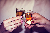 Two woman hands toasting whiskey, brandy with isolated backgroun