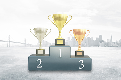 Sports pedestal with golden, silver and bronze winner cups on city background. 3D Rendering