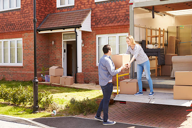 istock Couple Unpacking Moving In Boxes From Removal Truck 546201636
