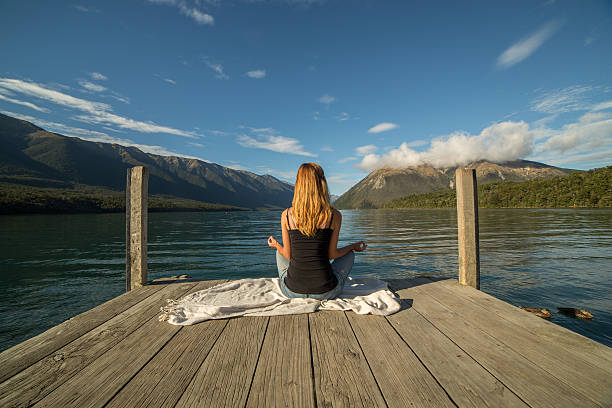 junge frau entspannt auf see pier, fitness-yoga - lake tranquil scene landscape zen like stock-fotos und bilder