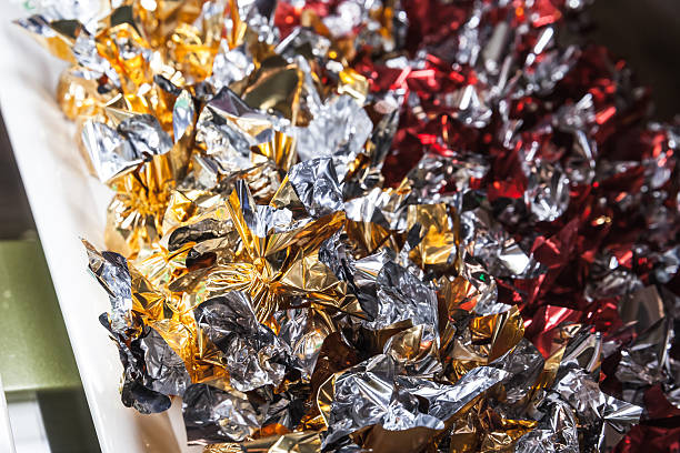 Candies in shining colorful wrappers lay on a market counter, close-up photo with selective focus