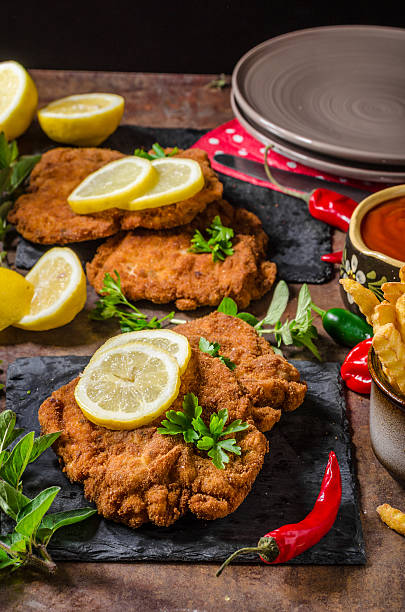 istock Schnitzel with fries, salad and herbs 546422750