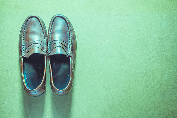 istock Brown leather shoes on wooden table, Style vintage 546425440