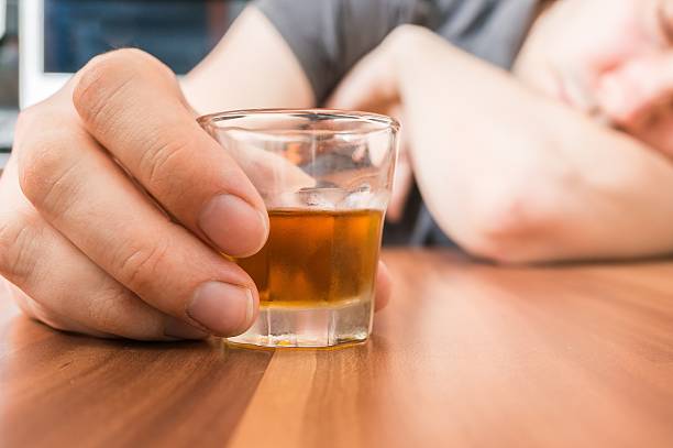 istock Alcoholic man is sleeping. Glass with alcohol in hand. 546425652