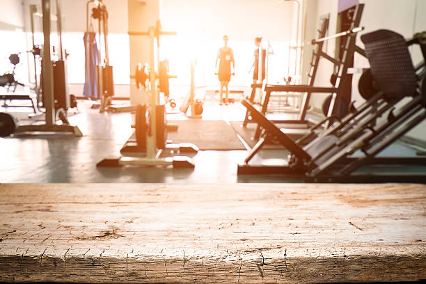 istock Fitness gym and empty wooden table space. 546425750