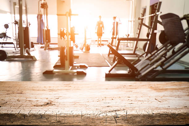 Fitness gym and empty wooden table space. stock photo