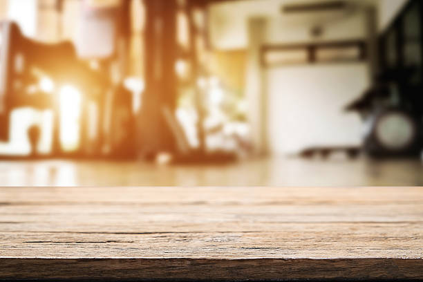 Wooden desk space and fitness gym background stock photo