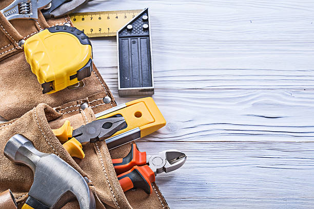 строительные инструменты в кожаном строительном поясе на деревянной доске - nobody hammer home improvement work tool стоковые фото и изображения