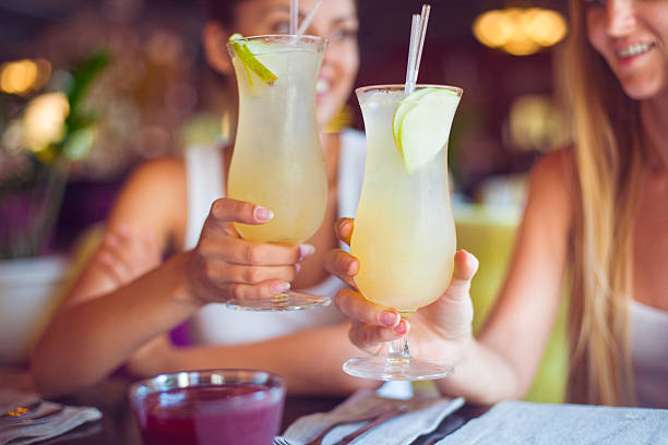 Two beautiful women having fun in a bar drinking cocktails