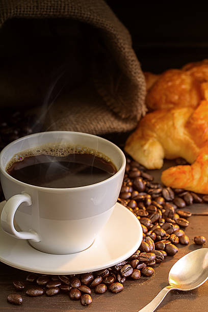 istock Hot coffee and croissant on wood table 546430206