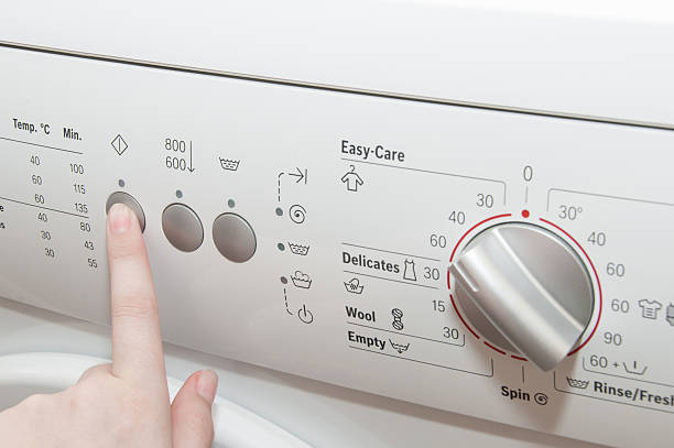 istock Close up of woman choosing cycle program on washing machine 546430502