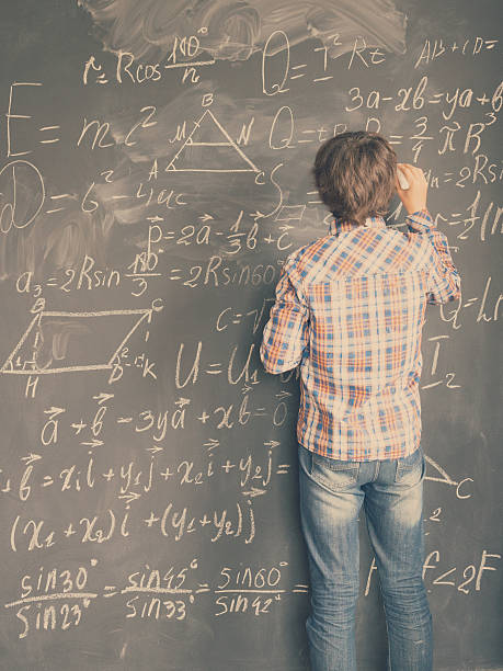 garçon écrivant sur un tableau noir - formula blackboard complexity scientist photos et images de collection