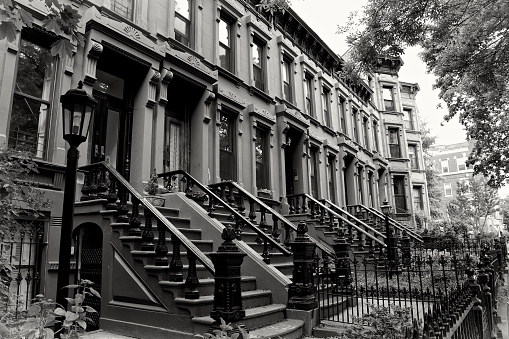 A group of Brownstone row homes c.1880’s-90’s are seen in the Park Slope neighborhood of Brooklyn, New York City, USA. These types of row house residential buildings are highly desired in New York City. The term 