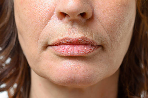 Closeup on the mouth of a middle-aged woman Closeup on the mouth of a middle-aged brunette woman with her mouth closed and a serious expression wrinkled stock pictures, royalty-free photos & images