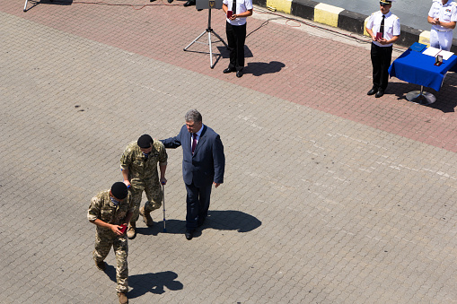 Odesa, Ukraine - July 03, 2016: President Petro Poroshenko helps wounded soldier after awarding. Navy day celebration in Odesa